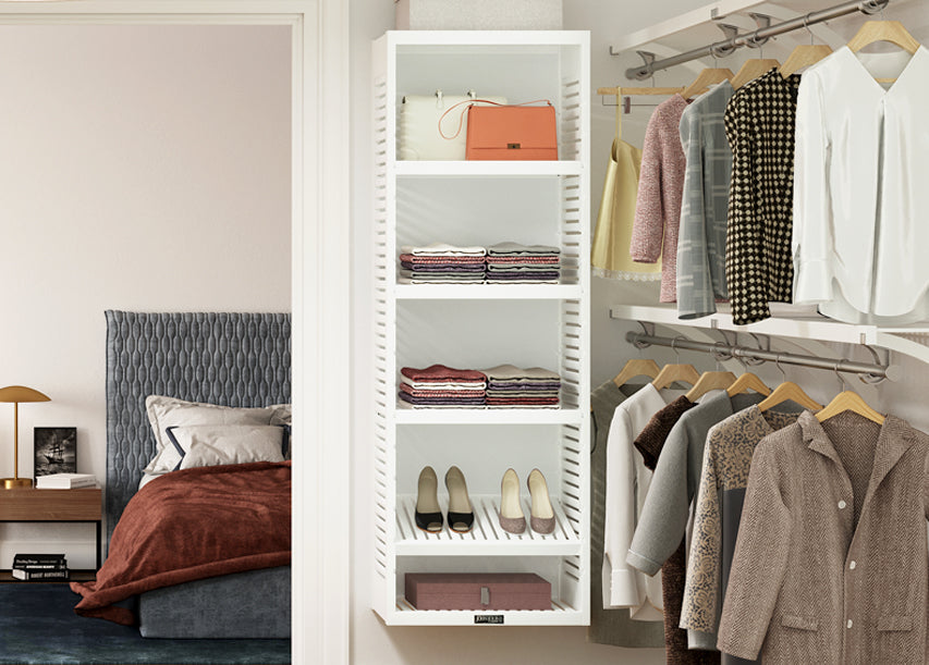 white storage tower with shelves in master bedroom closet with clothes hanging